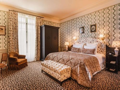 Cernay-la-Ville德沃塞尔奈修道院酒店的一间卧室配有一张大床和一把椅子
