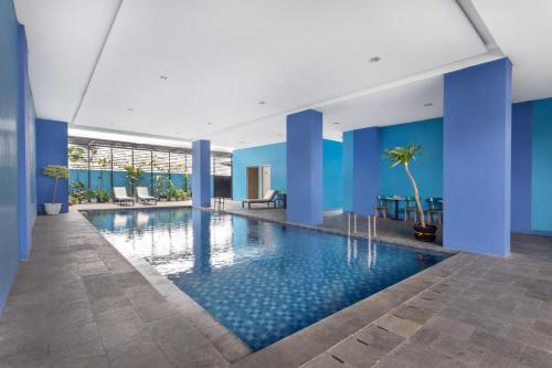 班达楠榜Arte Hotel Bandar Lampung的蓝色墙壁的建筑内的游泳池