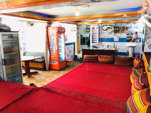 坎大哈Millat Hotel & Noor Jahan Hotel Kandahar的一间客厅,配有红色地毯和苏打水机