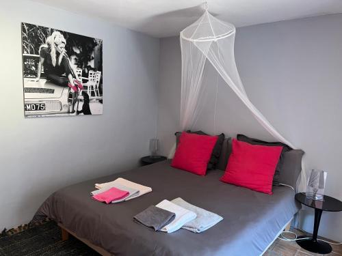 圣马克西姆蔚蓝达索特别墅酒店的一间卧室配有带粉红色枕头的床