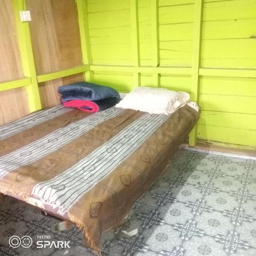 KohīmaAmen homestay的一张位于房间的床,上面有两个枕头