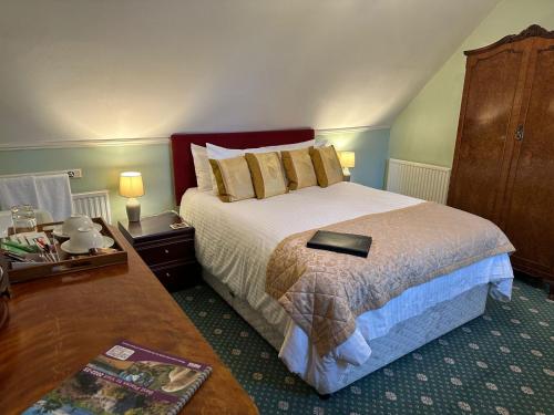 斯佩河畔格兰敦Ravenscourt House, Guest House & Restaurant的一间卧室配有一张床,上面有一本书