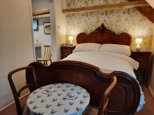 LuckingtonCotswold Cottage Bed & Breakfast的一间卧室配有一张大床和木制床头板