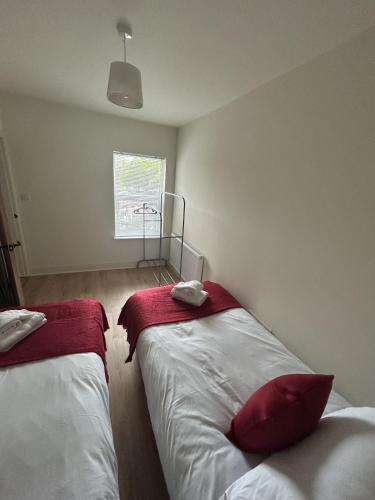 雷丁New 2 Bedroom Apartment in Reading的一间卧室设有两张带红色床单的床和窗户。