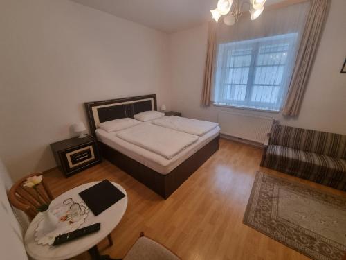 梅尔克维斯拉姆公寓的一间卧室配有一张床、一张桌子和一张沙发