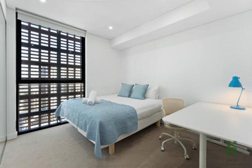 悉尼St Leonards 2B2B Apt with Skyview的白色卧室配有床和书桌
