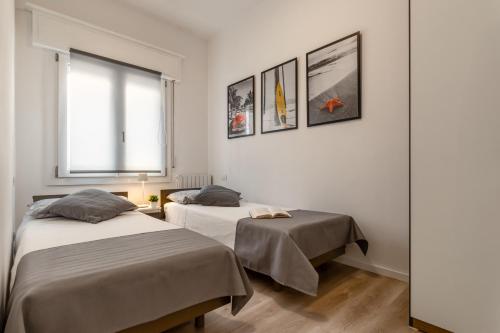 利多迪耶索罗GIGI HOUSE [appartamento PIAZZA MAZZINI] 300m dal mare的配有2张床的白色墙壁和窗户。