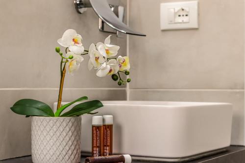 利多迪耶索罗GIGI HOUSE [appartamento PIAZZA MAZZINI] 300m dal mare的浴室设有白色浴缸和花瓶