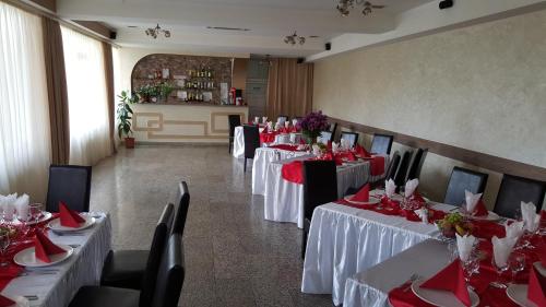 皮特什蒂阿帆加尔德餐厅旅馆的用餐室配有桌椅和红色餐巾