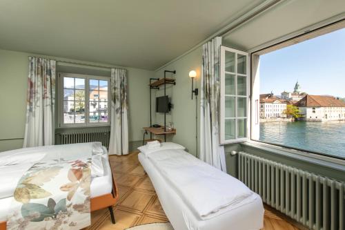 索洛图恩河畔阿勒瑞士优质酒店的一间卧室设有一张床和一个大窗户