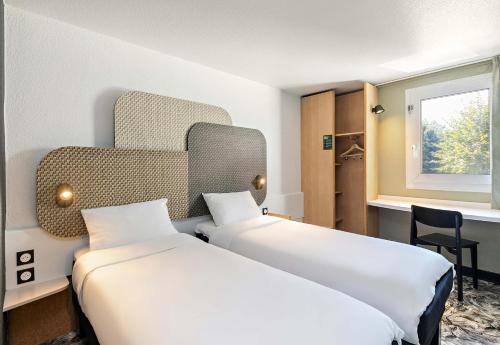 鲁昂B&B HOTEL Rouen Centre Rive Droite的酒店客房设有两张床和窗户。