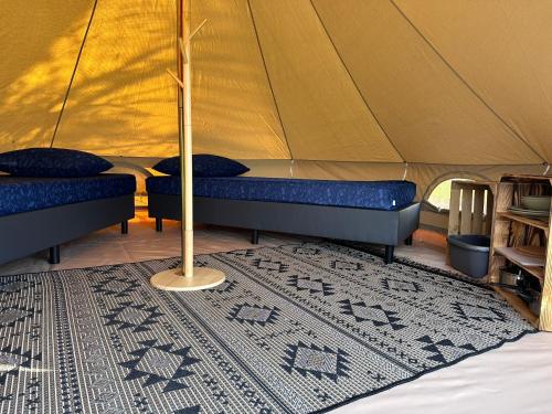 WarmondBell Tent的帐篷配有两张床和地毯
