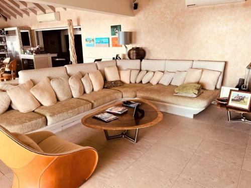 Jolly HarbourCasa frente al mar en Antigua的客厅配有大沙发和桌子