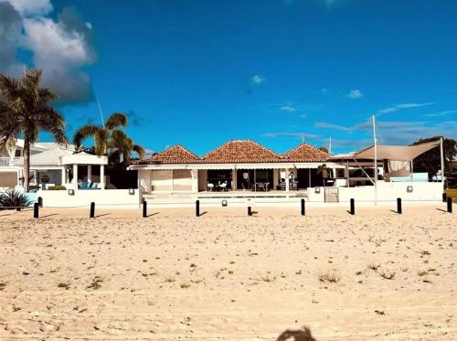 Jolly HarbourCasa frente al mar en Antigua的棕榈树沙滩上的一座建筑