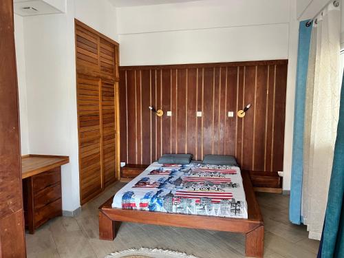 迭戈苏瓦雷斯Résidence Bleu Rivage的一间卧室设有一张床和木墙