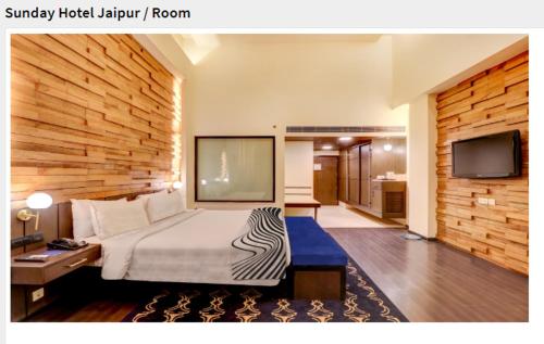 斋浦尔Sunday Hotel Jaipur的配有一张床和一台平面电视的酒店客房