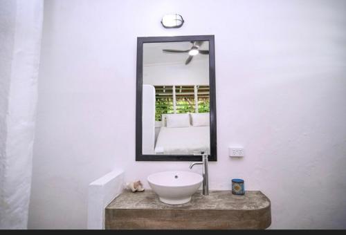 EtonBanana Bay Beach Club的浴室设有白色水槽和镜子