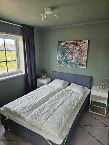 费尔耶斯塔登Ebbas stuga的卧室配有一张床,墙上挂有绘画作品
