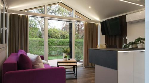 索勒恩LandZeit - get your tiny moments的一间带紫色沙发的客厅和一间厨房