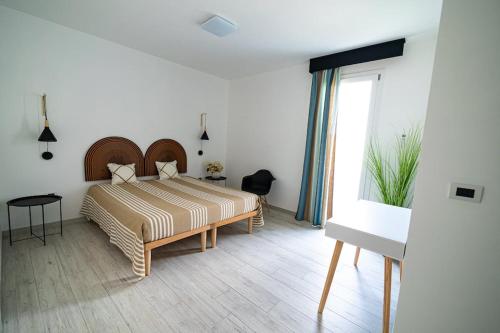 索尔索Appartamento Sorso的一间卧室设有一张床和一个大窗户