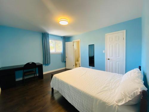 米西索加Riverwood Home的蓝色卧室配有一张床和一张书桌