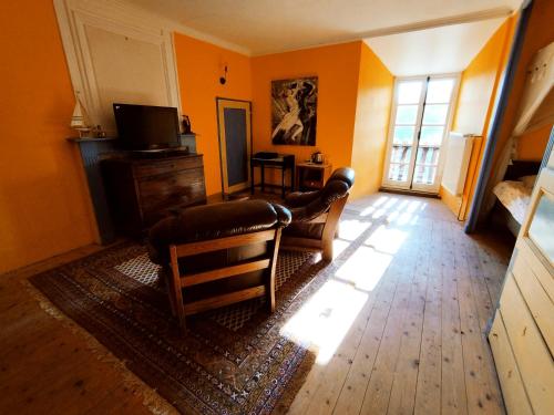 MontégutChateau Montegut的客厅设有橙色墙壁和电视。