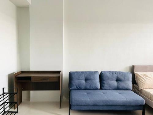 伊洛伊洛WV 4 Urban Studio的一张蓝色的沙发,位于带书桌的房间里