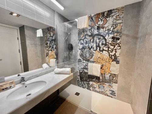 埃尔戈里亚加巴尔纳里奥厄尔格利伽酒店的浴室设有水槽和涂有涂鸦的墙壁