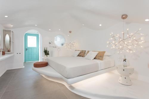 斯泰里达Naxos Cave Suites的白色卧室配有白色的床和吊灯