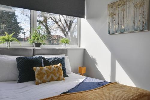 切姆Niche Sunrise Townhouse的一间卧室设有床铺和植物窗户