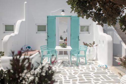 斯泰里达Naxos Cave Suites的一间设有蓝色门、一张桌子和椅子的房间