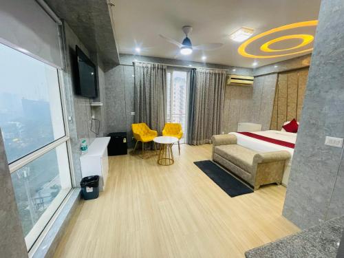 勒克瑙The Grace Residency, Lucknow的酒店客房带一张床、一张桌子和椅子