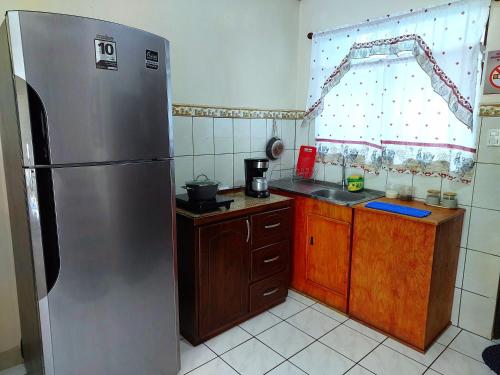 蓬塔雷纳斯Casa equipada en el centro de Puntarenas的厨房配有不锈钢冰箱和木制橱柜