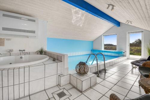 哈博尔Holiday home with spa and pool by the sea - SJ670的带浴缸和桌子的大浴室
