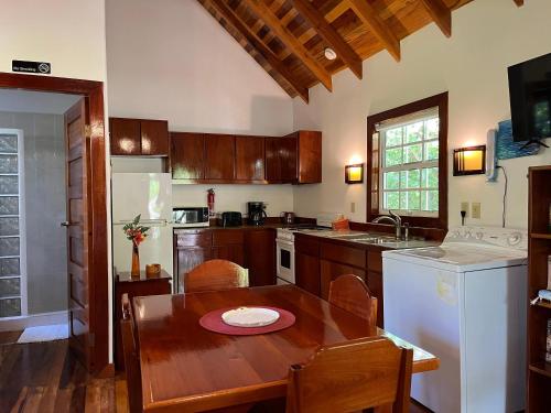 库尔克岛Sea Garden Cottage的一间带木桌的厨房和一间餐厅