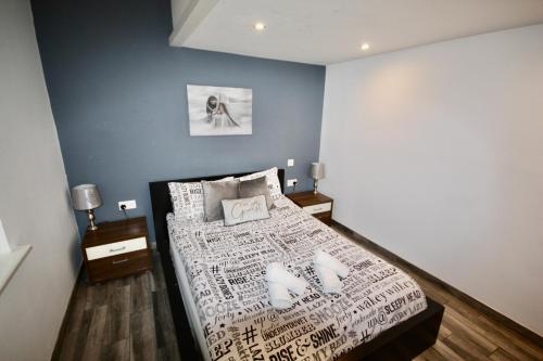 芬当Ferndown Holiday Let的一间设有床铺的卧室,位于一间拥有蓝色墙壁的房间