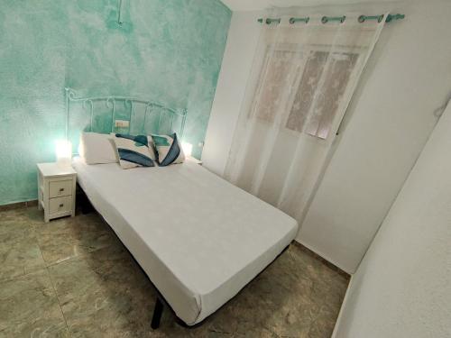 贝利雷瓜尔德Apartamento Gandia Bellreguard 3000的一间小卧室,配有白色的床和窗户