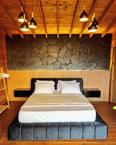 El QueremalEntre Nubes Eco Hotel的一张大床,位于一个石墙房间内