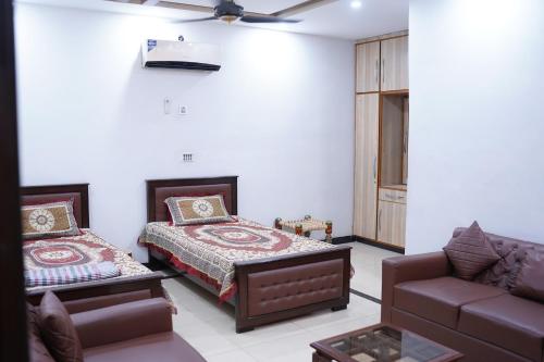 拉合尔Mohal's House的一间卧室配有一张床和一张沙发
