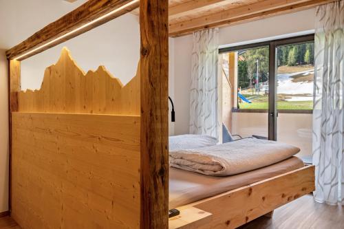 拉辛Blosegghof Bergchalets Apt Almwiese的木制客房的一张床位,设有窗户