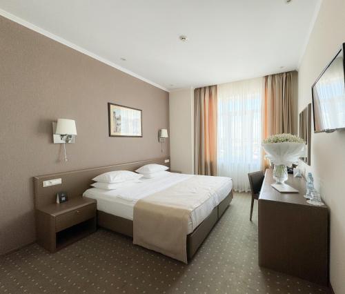 敖德萨亚历山德斯基酒店的配有一张床和一张书桌的酒店客房