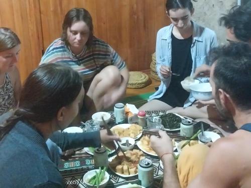 高平Trieu Hoan homestay的一群坐在桌子旁吃食物的人