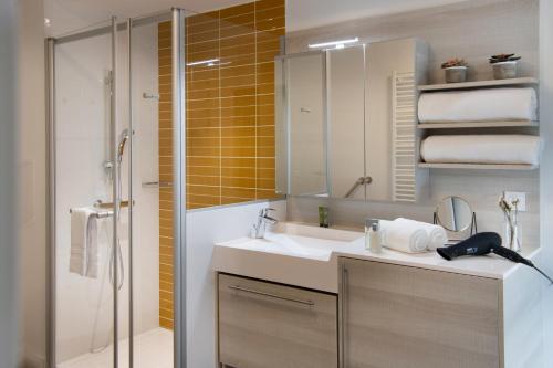 凡尔赛DOMITYS - Le Solstice的浴室配有盥洗盆和带镜子的淋浴