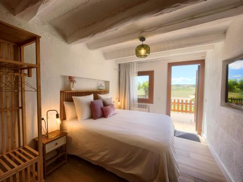 Pla del Panadés葡萄酒&烹饪派内迪斯住宿加早餐旅馆的卧室设有一张大白色床和阳台