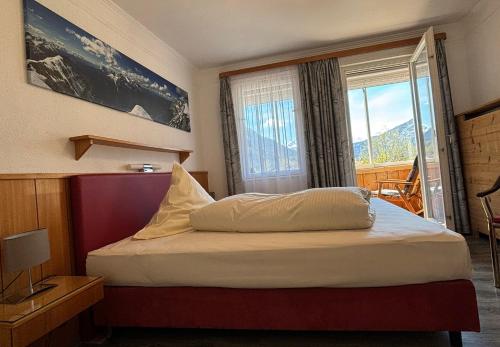 米滕瓦尔德Pension Bavaria的一间卧室设有一张大床和大窗户