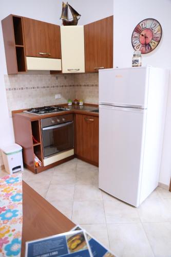 巴勒莫Politeama guest house Palermo Mimosa的厨房配有白色冰箱和木制橱柜。