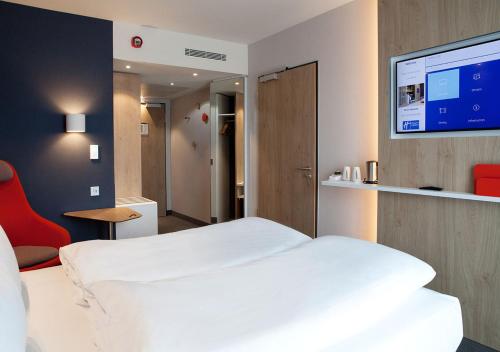 杜塞尔多夫Holiday Inn Express - Düsseldorf Airport的卧室配有白色的床和平面电视。