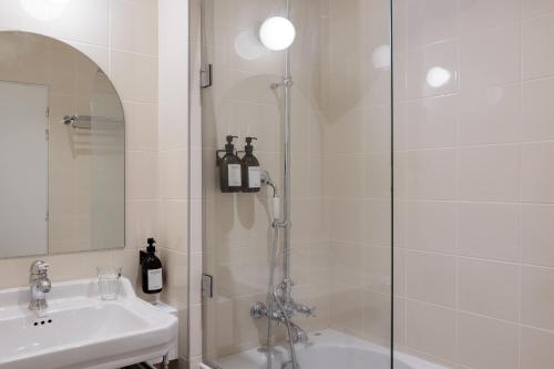比亚里茨ALFRED HOTELS Port-Vieux - Ex Georges VI的带淋浴和盥洗盆的白色浴室