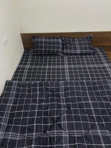 岑山Ngất Ngây Homestay的一张配有黑白床单和枕头的床