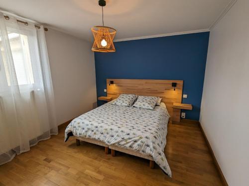 Gîte Oison, 2 pièces, 2 personnes - FR-1-590-428的一间卧室配有一张蓝色墙壁的床